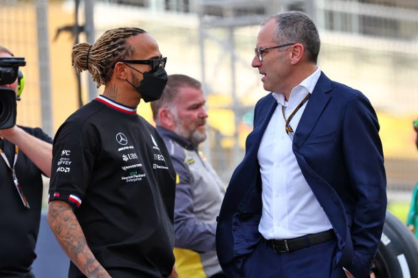 Hamilton e Domenicali fotografati mentre stanno avendo un colloquio.