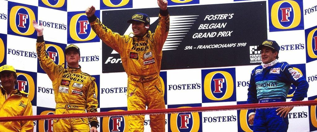 Hill festeggia la vittoria sul podio assieme al compagno di squadra ed Alesi