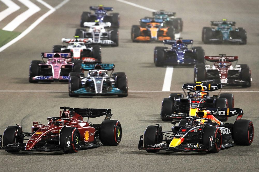 Auto da corsa in competizione durante il Gran Premio di Bahrain, con vetture Ferrari in evidenza e altre scuderie sullo sfondo.