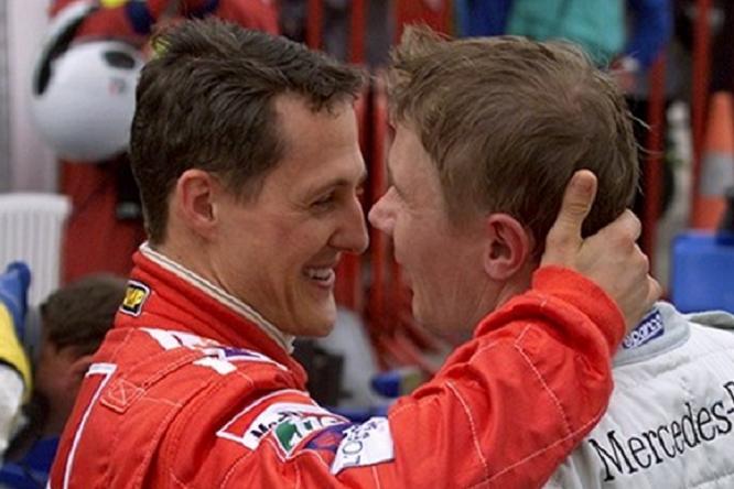 Mika Hakkinen e Michael Schumacher si abbracciano nel paddock dopo la gara, evidenziando il rispetto reciproco tra i due piloti rivali. Hakkinen vs Schumacher.